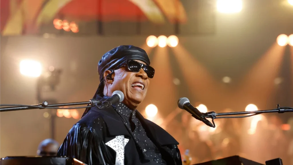 Stevie Wonder smiling at the keyboard on stage