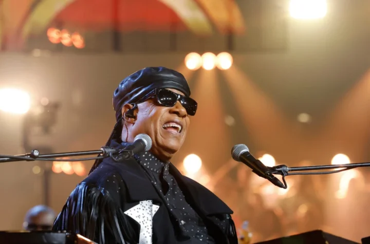 Stevie Wonder smiling at the keyboard on stage